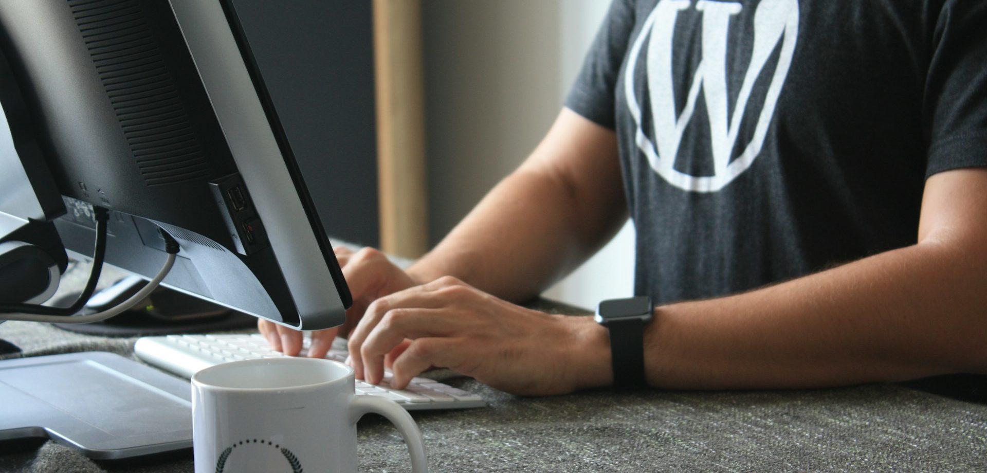 A WordPress developer wearing a WordPress branded t-shirt